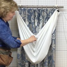 a woman is holding onto a white hammock in front of a shower curtain