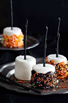 halloween desserts with marshmallows and sprinkles on black plates