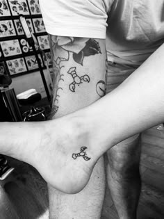 two people with tattoos on their legs and one is holding the other's leg