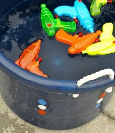 plastic toys are floating in a blue bucket