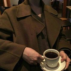 a woman holding a coffee cup and saucer