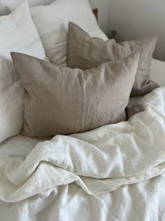 a bed with white linens and pillows on it