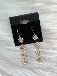 *Mini multi daisy drop down earring *Four mini white and yellow flowers *Gold metal *Fish-hook style *2" X 0.375" White And Yellow Flowers, Metal Fish, Jewelry Candles, Pearl Hoop Earrings, Backpack Tote Bag, Dress Jewelry, Rose Earrings, Wide Brimmed Hats, Acrylic Earrings