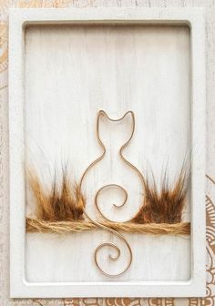 a white frame with a cat on it and some brown hair in front of it