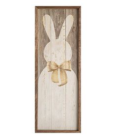 a wooden sign with an image of a white rabbit wearing a bow on it's head