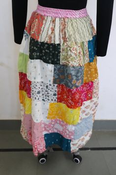 a woman wearing a skirt made out of multicolored fabrics on a mannequin