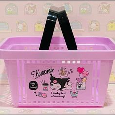 a pink plastic basket with stickers on the front and sides, holding a black handle