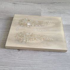 a wooden cutting board with two pieces of glass beaded on the top and one piece of wood that has been cut in half