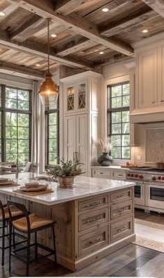 a large kitchen with an island in the middle and lots of windows on both sides