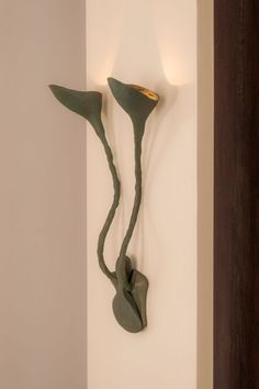 a wall mounted light fixture with two lights on it's sides and an artistic design in the middle