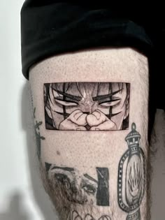 a man's leg with tattoos on it and an image of the face of gohan