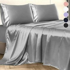 a bed covered in silver sheets and pillows