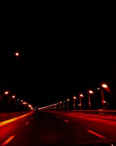 an empty highway at night with street lights