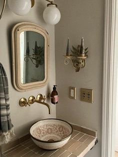 a bathroom sink sitting under a mirror on top of a wooden counter next to a doorway