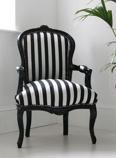 a black and white striped chair next to a potted plant