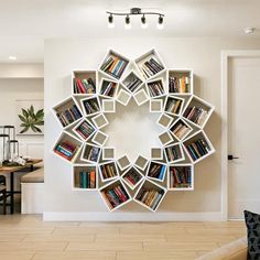 a circular book shelf filled with lots of books on top of a tiled floor next to a dining room table