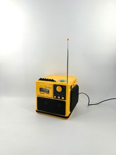 a yellow and black radio sitting on top of a white table next to a light