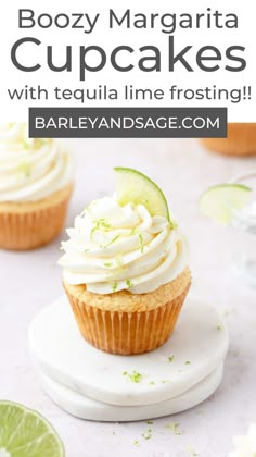 a cupcake with white frosting and limes on top is sitting on a plate