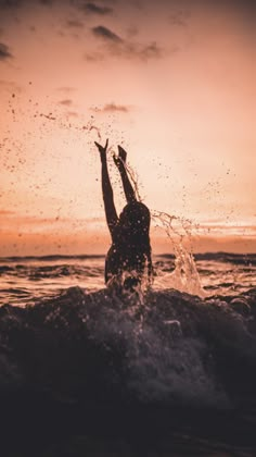 a person jumping into the water at sunset