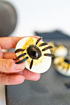 a person is holding an egg decorated like a spider