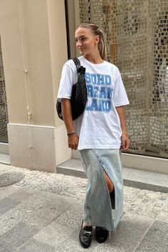 Foto: lara__brucker - Look casual com t-shirt oversized, bolsa baguete, saia jeans longa e mocassim preto.