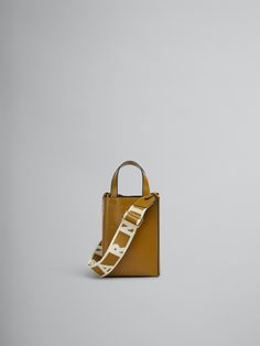 North/South tote bag, nano size, in calf leather with internal slot pocket. Leather top handles and detachable shoulder strap, adjustable with buckle. Gold hardware. Gold printed logo outside. Trunk Bag, Gold Print, Lacing Sneakers, North South, Boot Accessories, Cool Socks, Shopping Bags, Small Leather Goods, Kids Bags