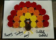 a turkey made out of cupcakes and flowers on a white plate with the words happy turkey gobble gobble