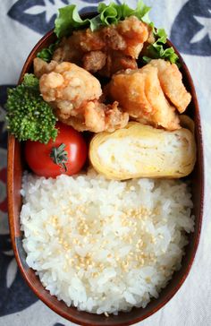 a bowl filled with rice, meat and veggies on top of a table