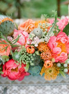 an arrangement of flowers and succulents on a table