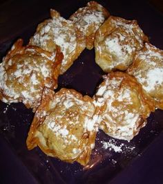 some powdered sugar covered pastries on a purple plate