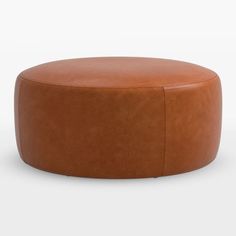 a brown leather ottoman sitting on top of a white floor