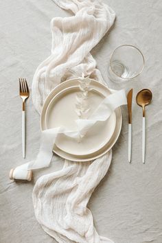 the table is set with silverware and napkins, along with a white cloth