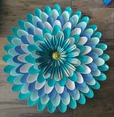 a blue and white paper flower sitting on top of a wooden table