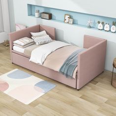 a pink bed sitting on top of a wooden floor