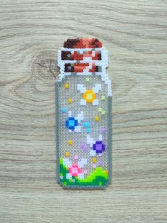 a plastic bottle with beads in it sitting on a wooden surface