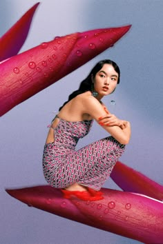 a woman sitting on top of a red object with water droplets flying around her head