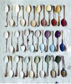 many spoons are lined up in rows on the wall with different colors and sizes