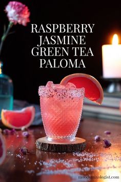 raspberry jasmine green tea paloma cocktail in a glass on a wooden table