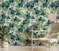 a chair and table in front of a wallpapered with blue berries on it