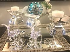 a silver tray topped with candles and glass figurines