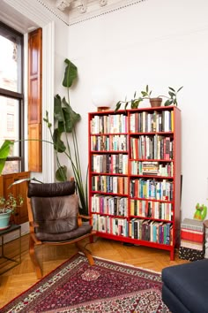 a living room filled with furniture and a book shelf covered in lots of different types of books