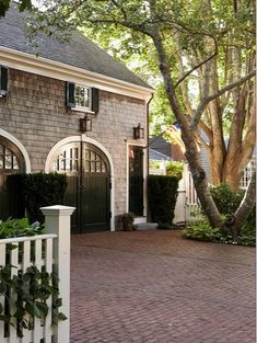 a brick driveway leading to a large house