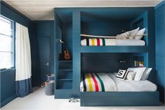 two bunk beds in a room with blue walls