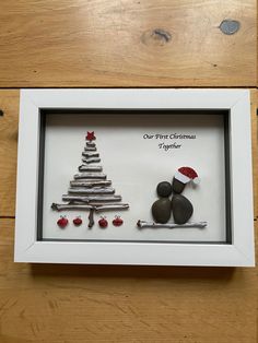 a white frame with some rocks and a christmas tree