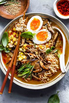 an overhead view of a bowl of ramen soup with noodles, mushrooms and eggs