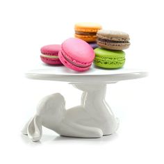 macaroons are sitting on top of a white cake plate