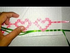 someone is stitching together pink and green ribbon