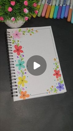 an open notebook sitting on top of a table next to crayons