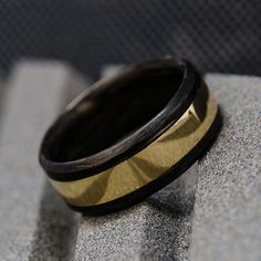 a black and gold ring sitting on top of a gray carpeted floor next to a wall