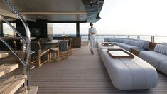 a woman standing on the deck of a boat looking out at the water and stairs